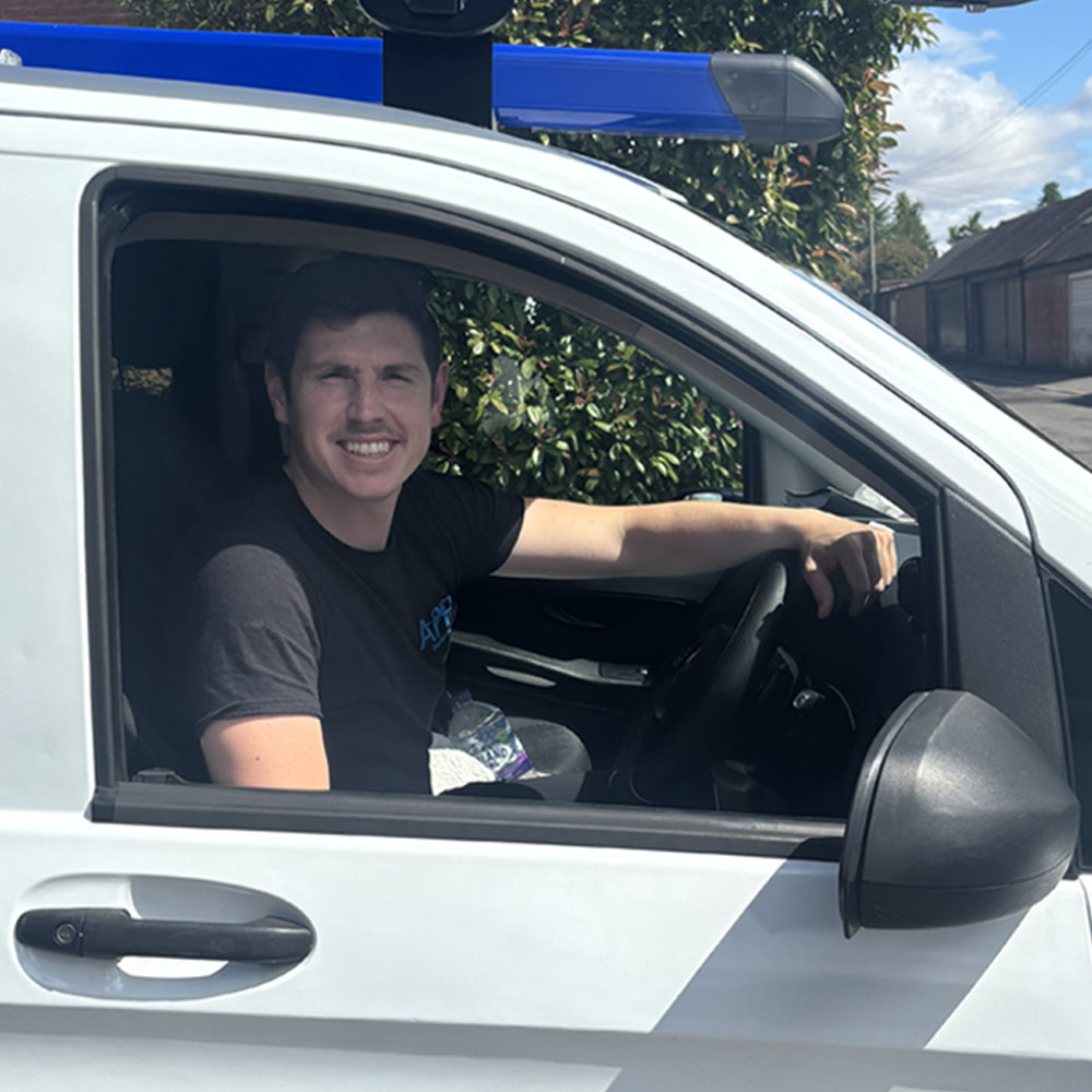 Andrew, Owner of APP Electrical, sat inside of company vehicle.